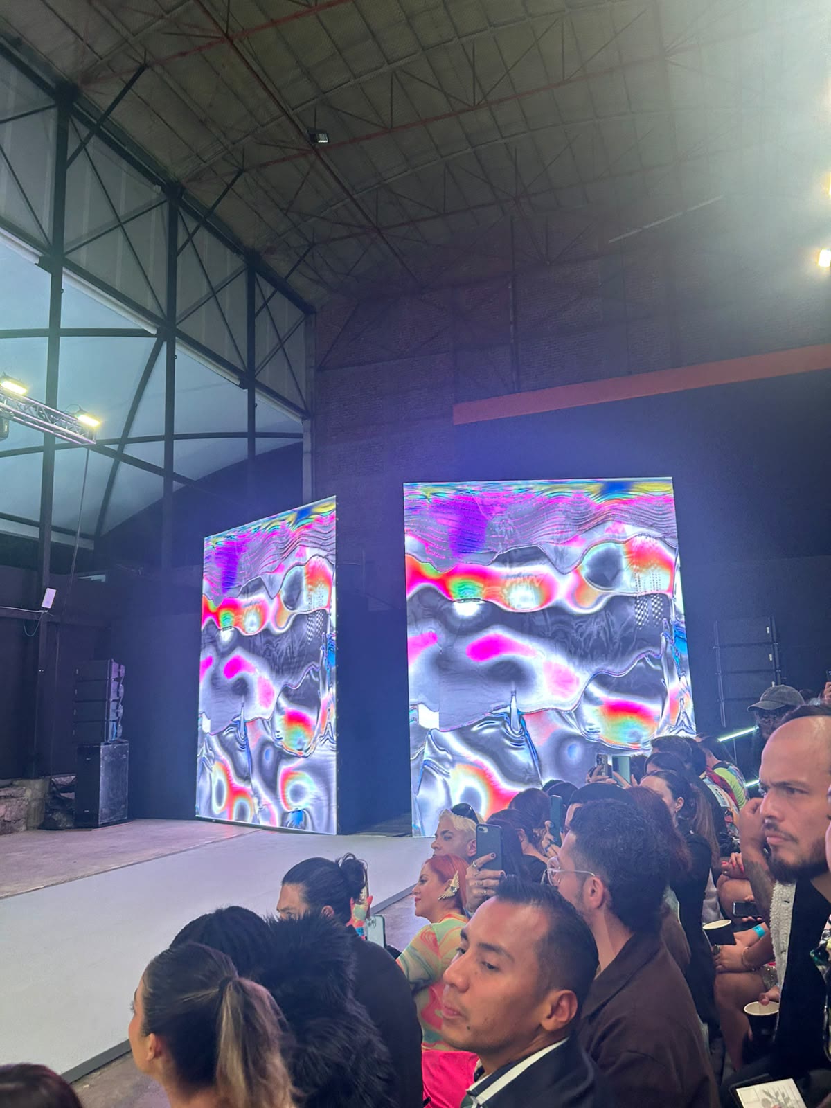 Audience watching paired LED walls filled with iridescent WAVEY visuals during the show